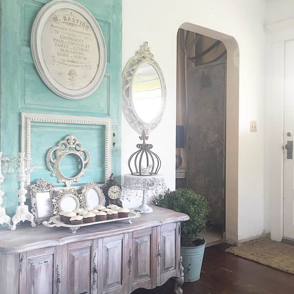 blue door with white frames and mirrors and cupcakes on a tray