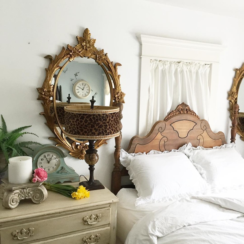 large gold mirror bedside with leapord lamp beside white linen bed