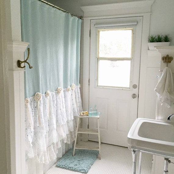 Blue and white lace bathroom shower curtain in white bathroom with blue rug and white step ladder