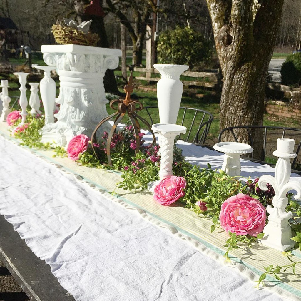 Vintage Outdoor Garden Party Decoration Ideas white candle holders scattered throughout the center of the table with pink flowers and white table cloth