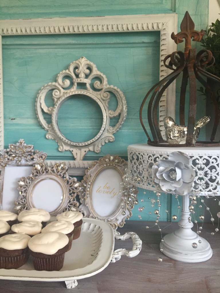 blue door with white farmes and white tray filled with cupcakes