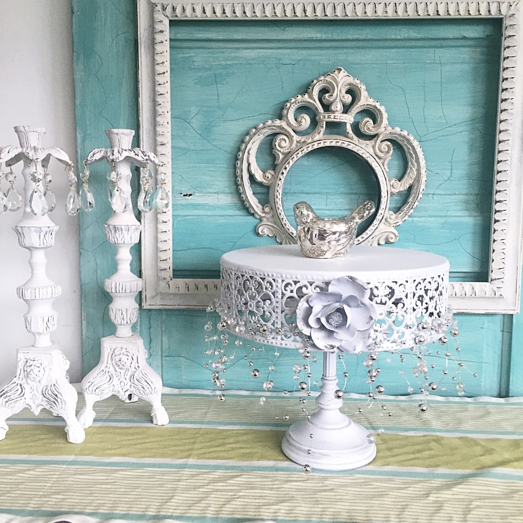 blue door white 2 white frames and white cake stand with 2 white candle holders