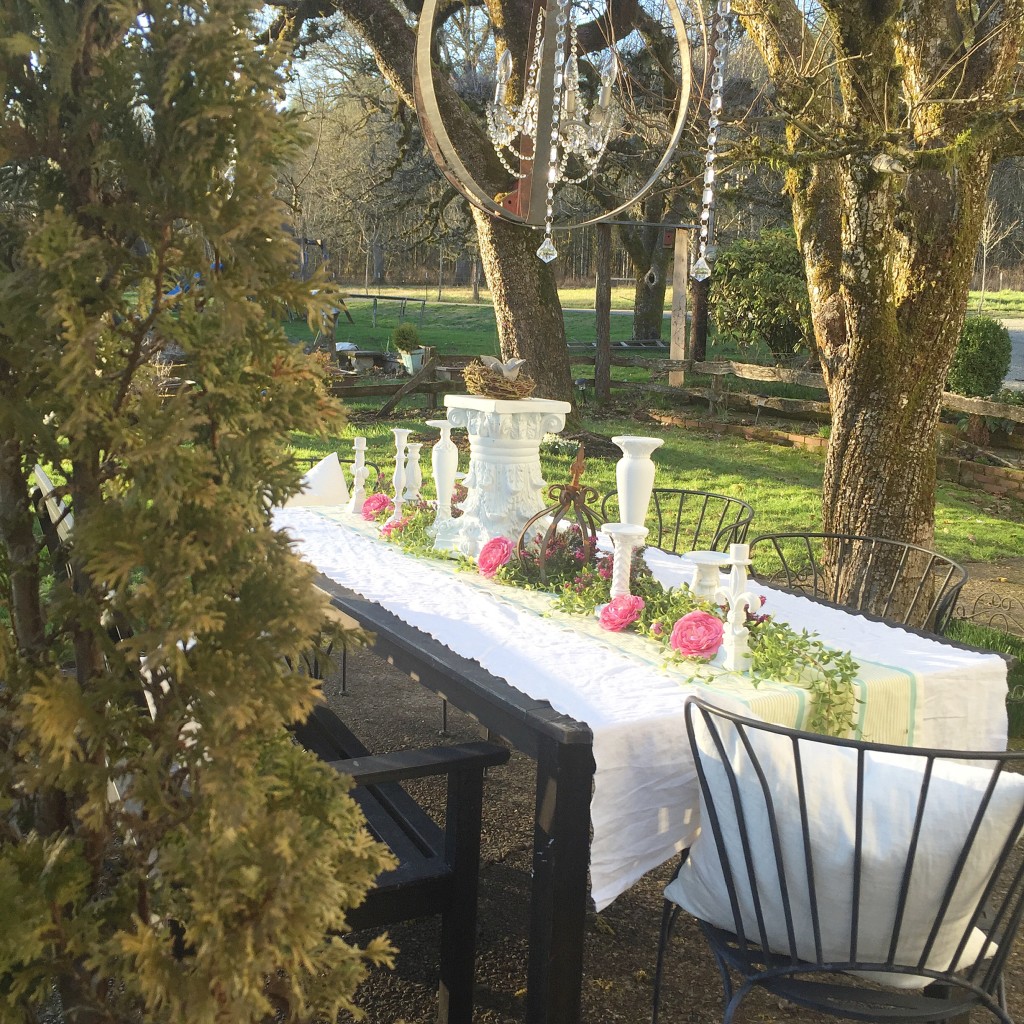 white table cloth outside setting with chandelier and white candle holders