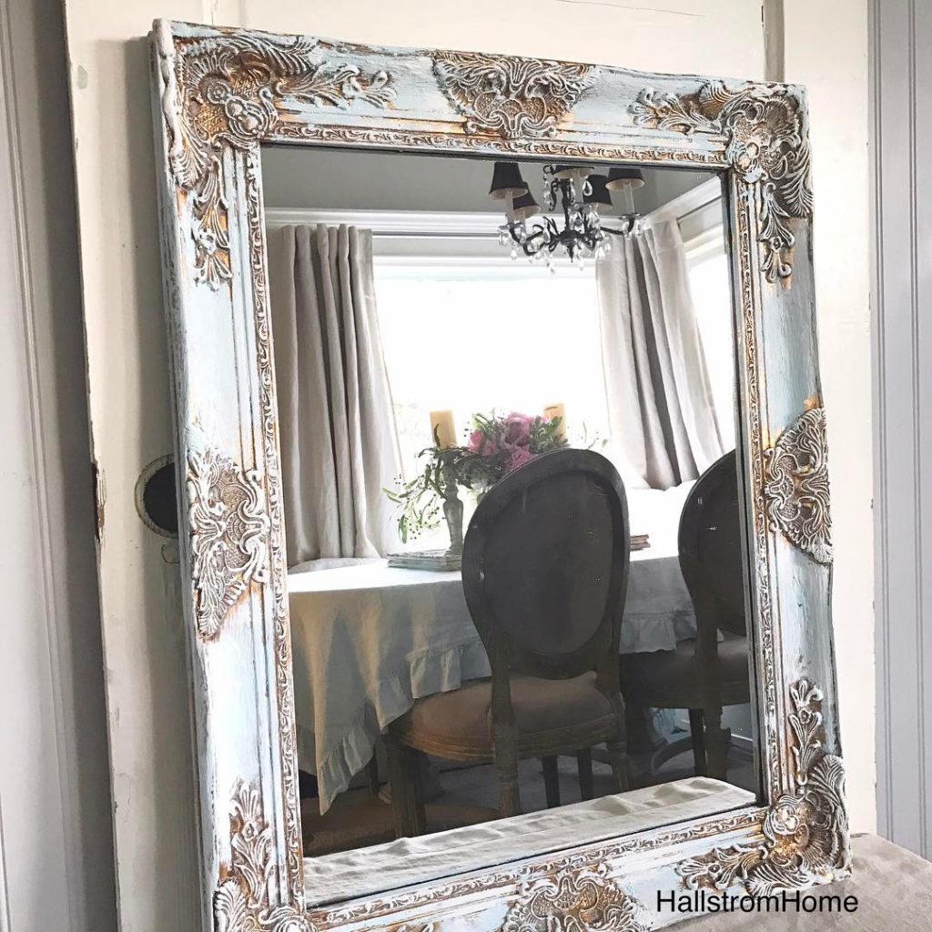 blue white and gold mirror leaning against antique white door