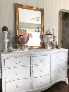 Sweet and Easy Valentines Party Decor with Heart Banner grey dresser with gold mirror and 4 candle holders