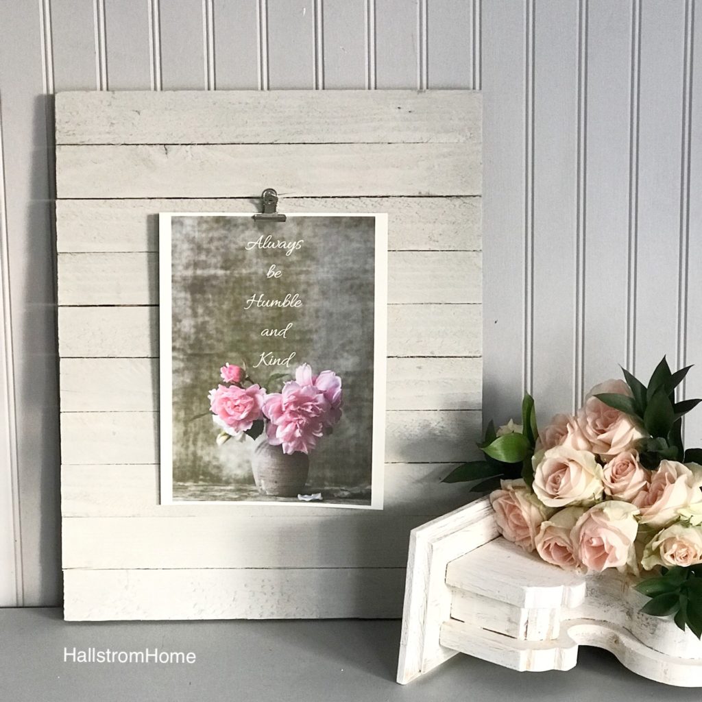 white wood board leaning with pink flower printable and white corbel nest to it with pink roses