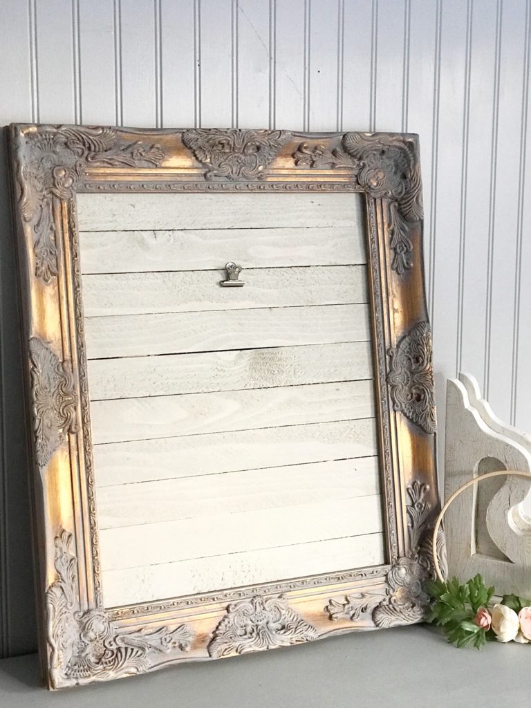 white wood with gray and gold frame framing wood. White corbel and the side of leaning frame