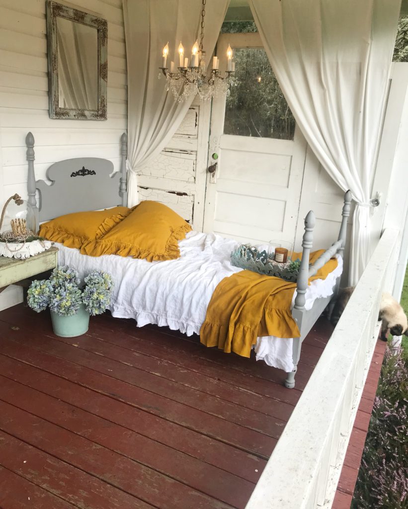 2 yellow pillow shams on white bed sleeping porch