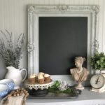 gray vintage chalkboard with white vase filled with lavender and cupcake tray with 4 white cupckaes and roman but