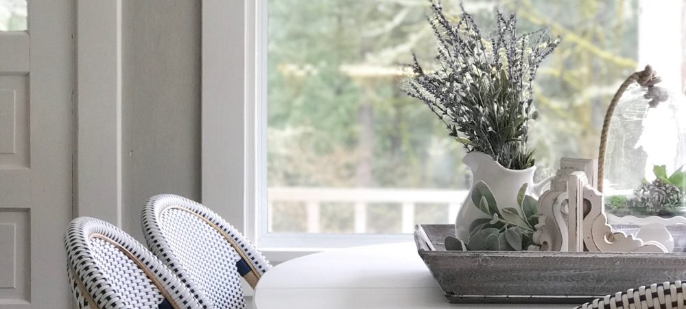 Breakfast Room Table Makeover / Chalk Paint Recipe white farmhouse table with 3 blue and white chairs with woodent tray ontop filled with lavender wreatha dn whtie corbel with cloche