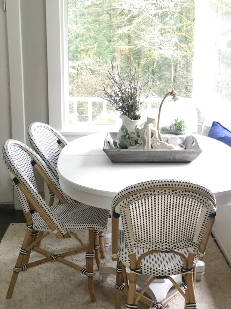 Breakfast Room Table Makeover / Chalk Paint Recipe white farmhouse table with 3 blue and white chairs with wooden legs and wooden tray ontop filled with lavender wreaths dn white corbel with cloche