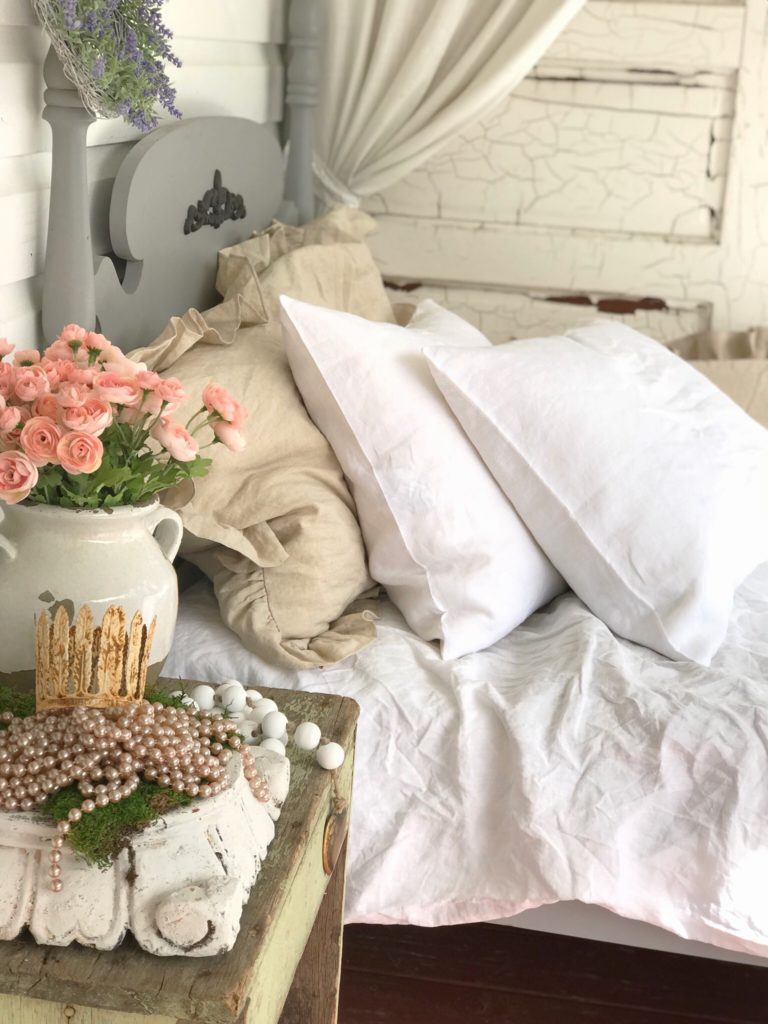 2 white linen pillows and ruffle brown pillows on white bed