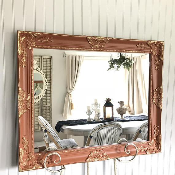 orange and gold overlay mirror on easel with table and chairs in reflection