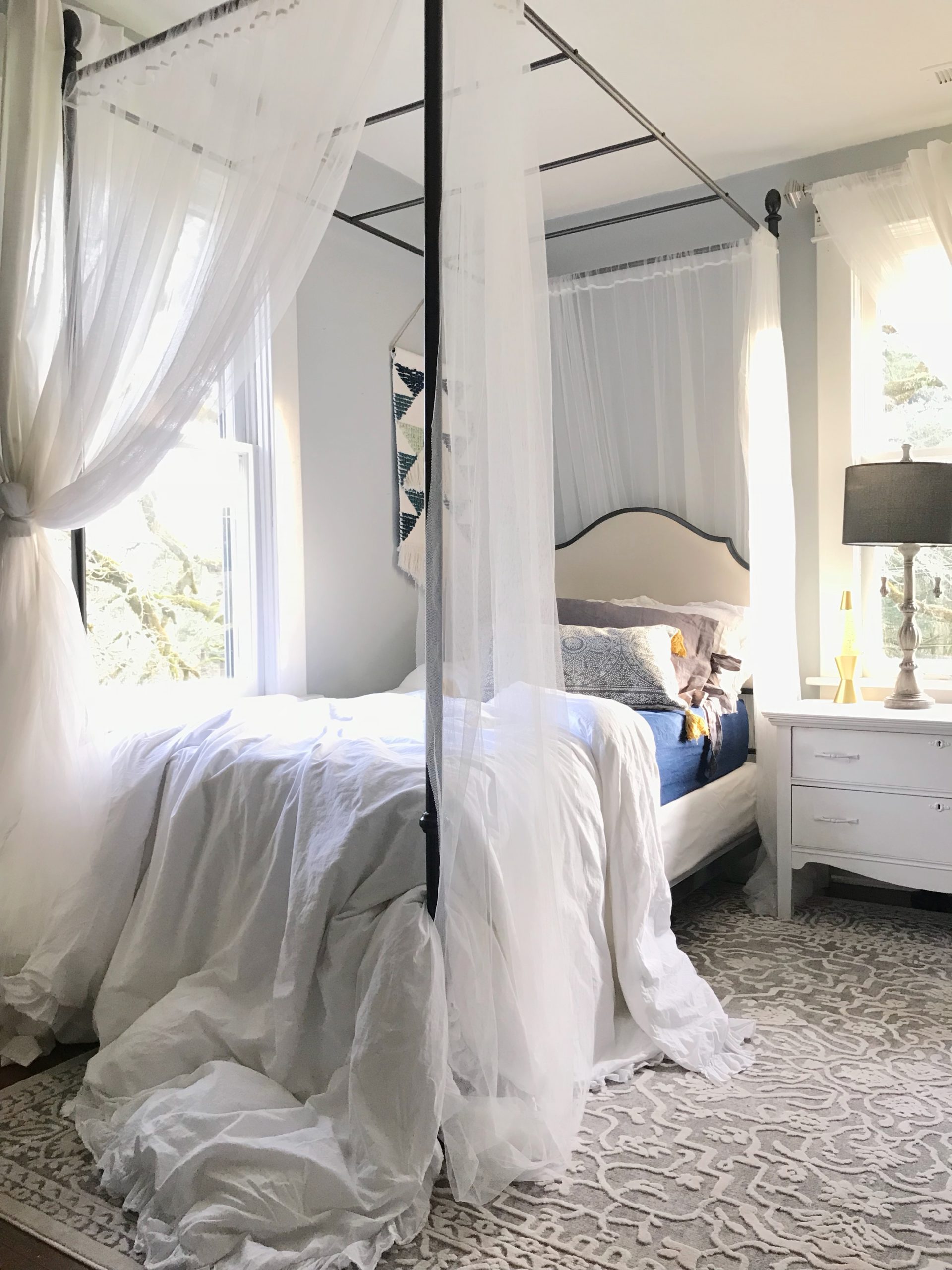 Part 2: Our 100 Year Old Farmhouse Spring Tour canopy twin bed with white canopy. white ruggle sheet draped off bed with blue sheets and white nightstand
