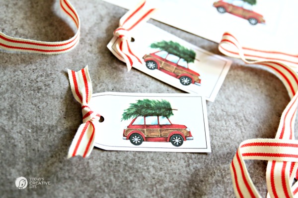 vintage red car with christmas tree on top gift tag printables with red and white stripe ribbon tied to them