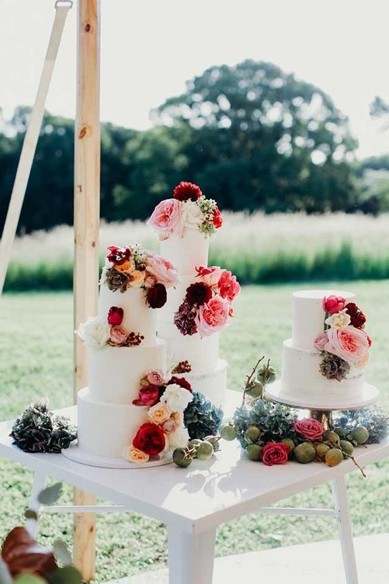 3 separate cakes with deep red flowers all on them