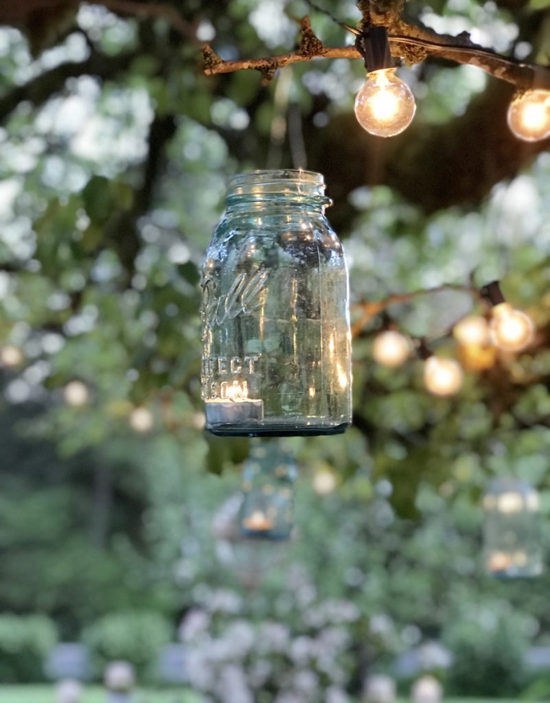 1 blue mason jars hanging from tree with lights