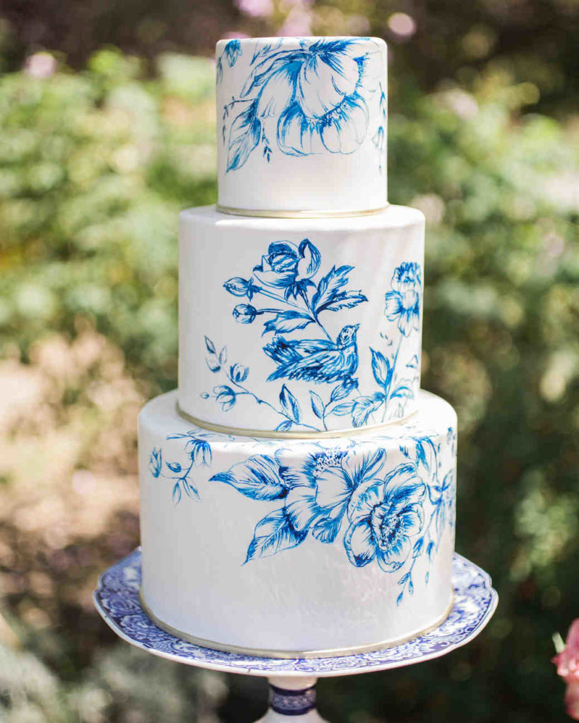 white cake with blue paint work of flowers