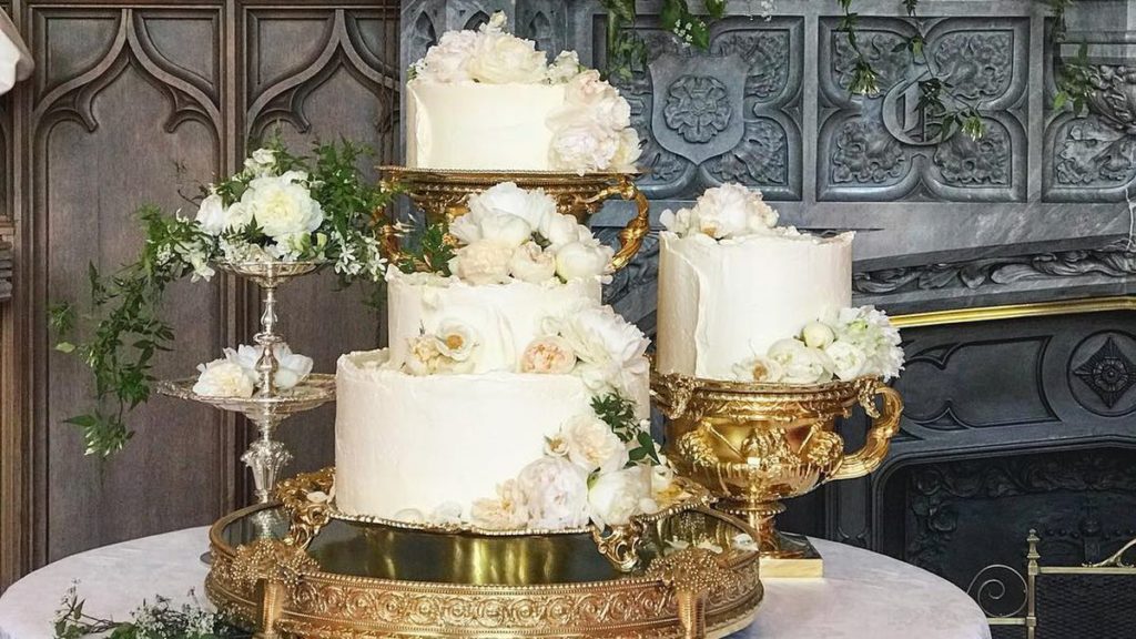 20 Most Beautiful Wedding Cakes You'll Want to See 3 seperate white frosted cakes with white flowers all on gold platters