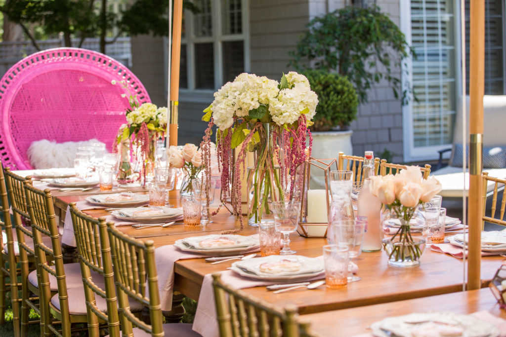 20 Most Beautiful Wedding Cakes You'll Want to See with wood table outside with gold chairs and one big pink chair with tall clear vases with white flowers