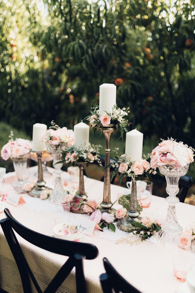 tall gold candle holders with pink flowers and white candles