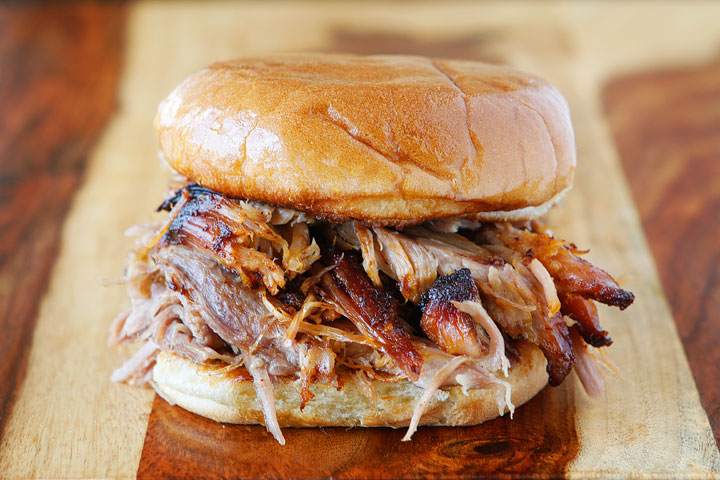 pulled pork sandwich on wood cutting board