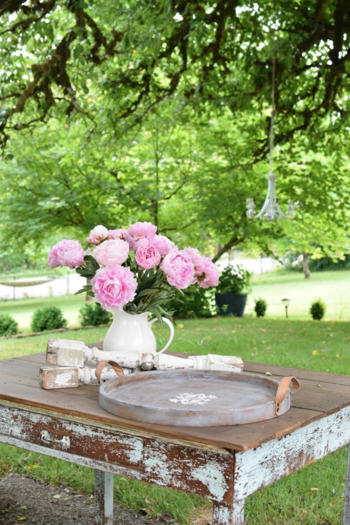 wood table with wood round tray and bouquet of flowers