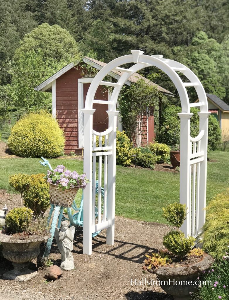 white arbor leading to garden