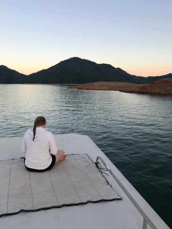 girl ontop of boat on sleeping bag