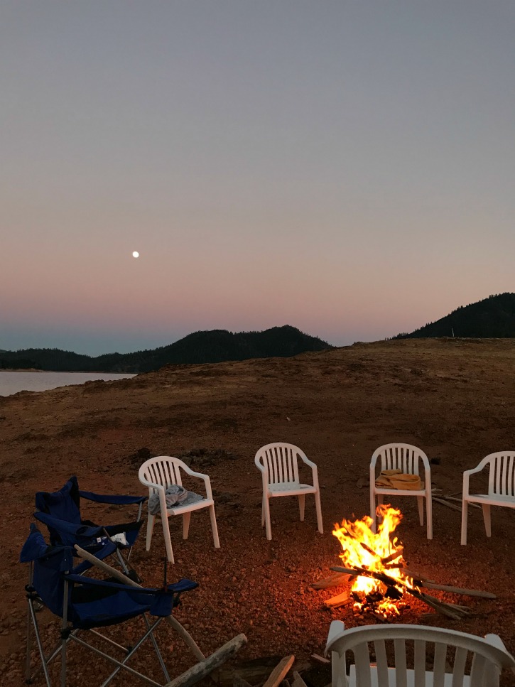 chairs around campfire on shore