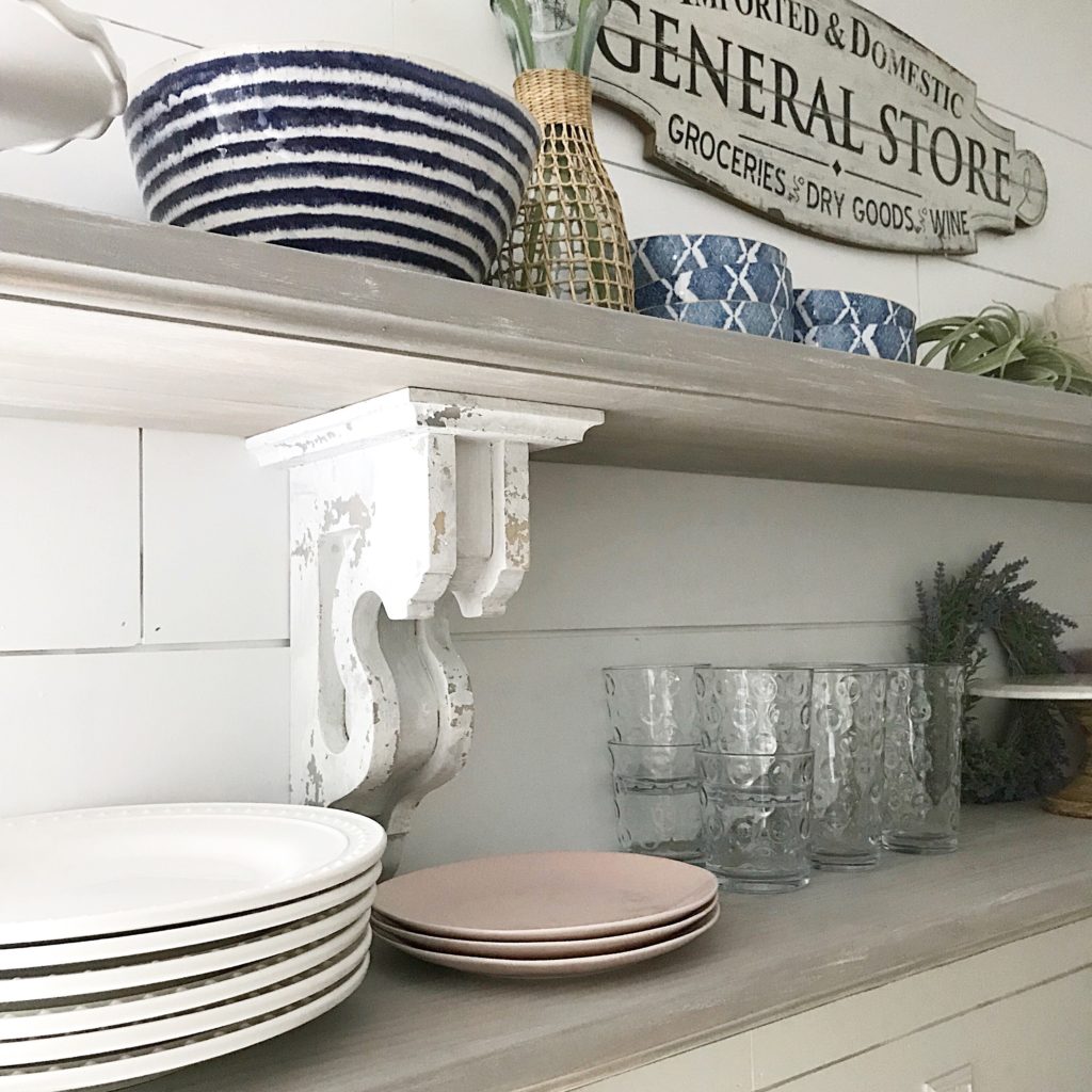 corbel shelf with plate and cups on it