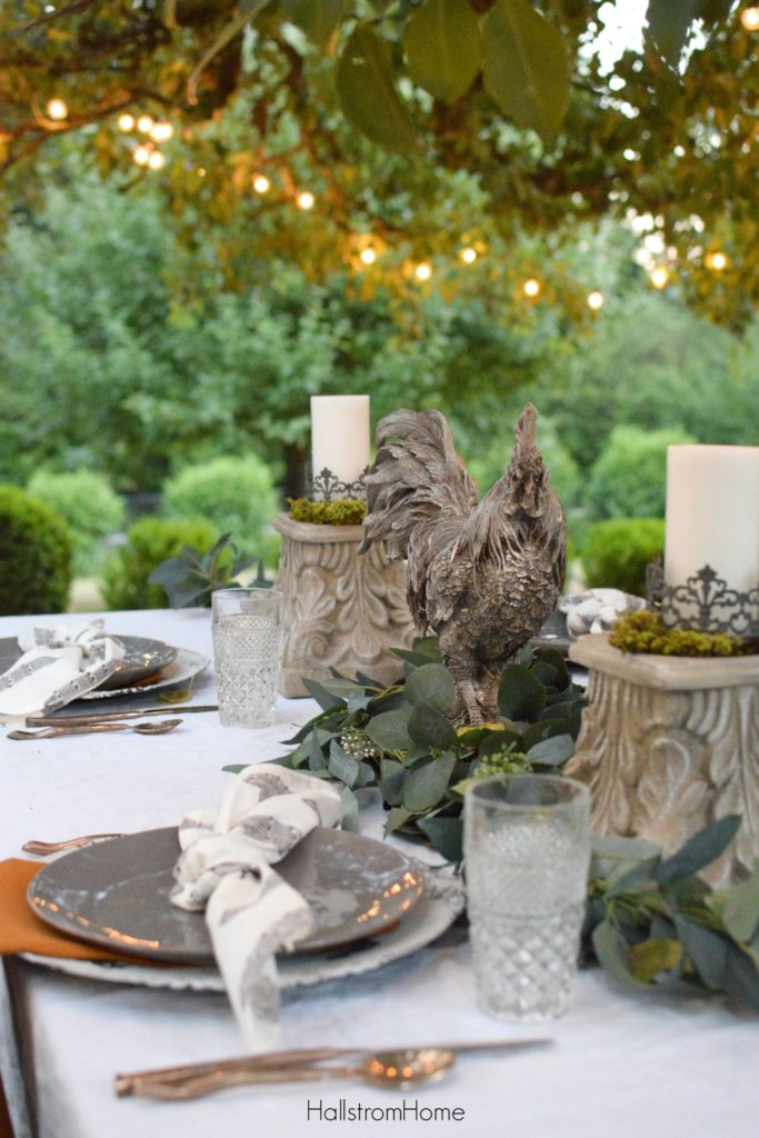 fall table with rooster centerpiece and 2 candle pedestals