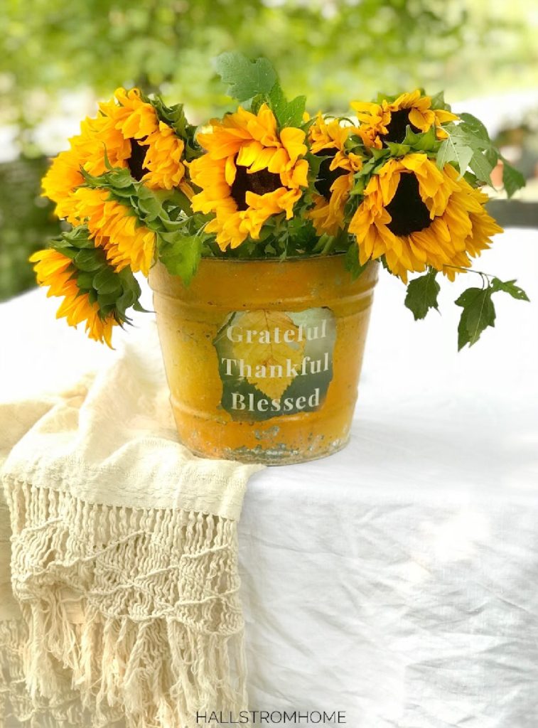 yellow bucket with sunflowers on white linen table cloth