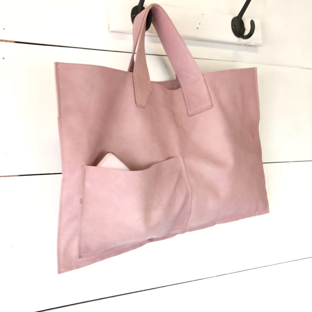 pink leather bag hanging on hook