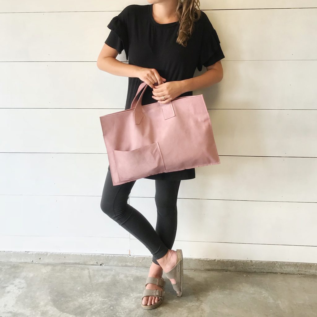 girl in all black holding pink leather bag