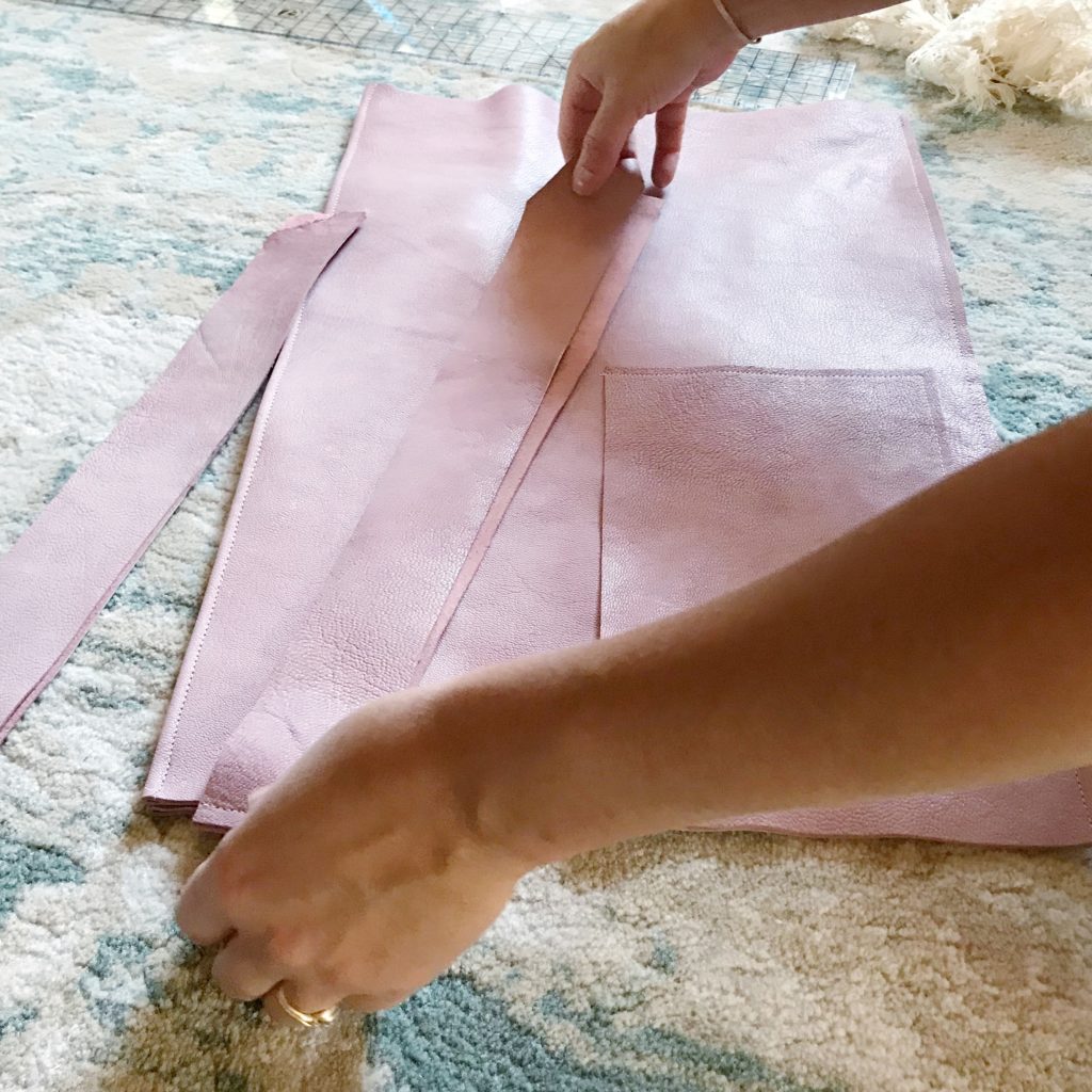 pink leather bag measuring the straps on top of bag