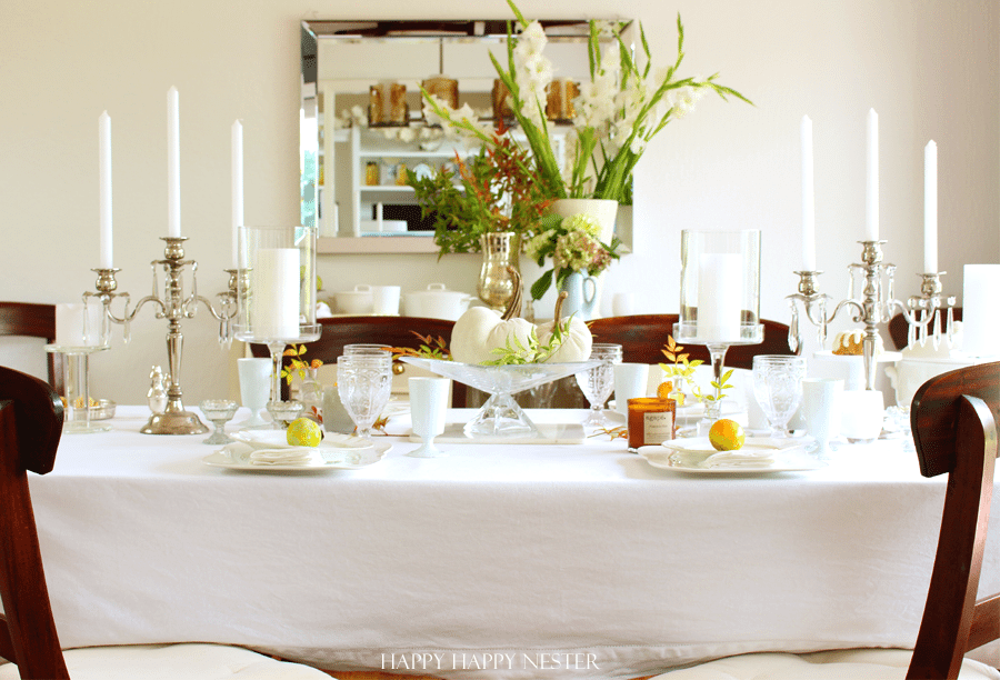 white table cloth with 2 candelabras and table setting with oranges