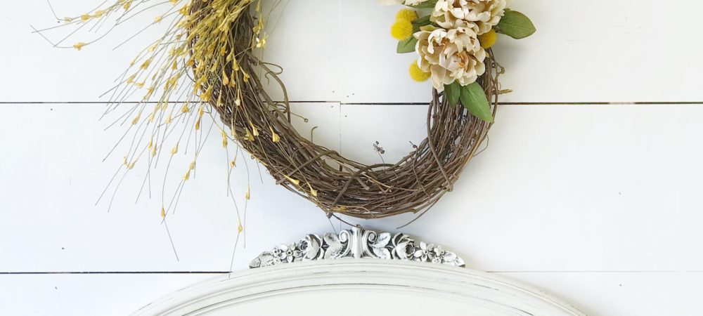 How to Make a Fall Wreath for Your Home wreath above white headboard and 2 yellow linen pillows