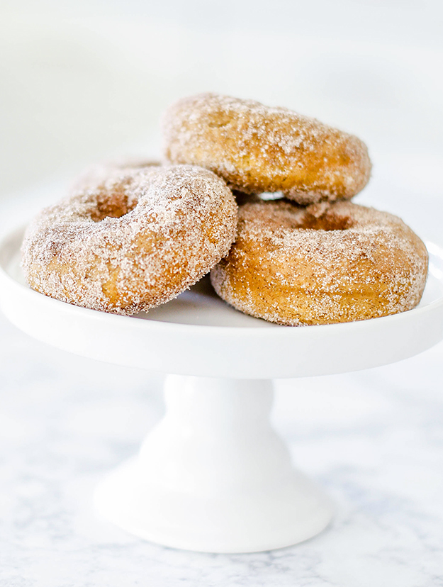 3 sugared donuts on white cake platter