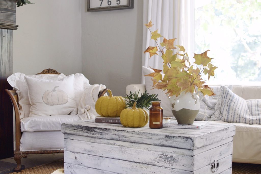 Beautiful Fall Farmhouse Home Tour with Easy Scone Recipe with white trunk with 2 pumpkins vase and candle on top