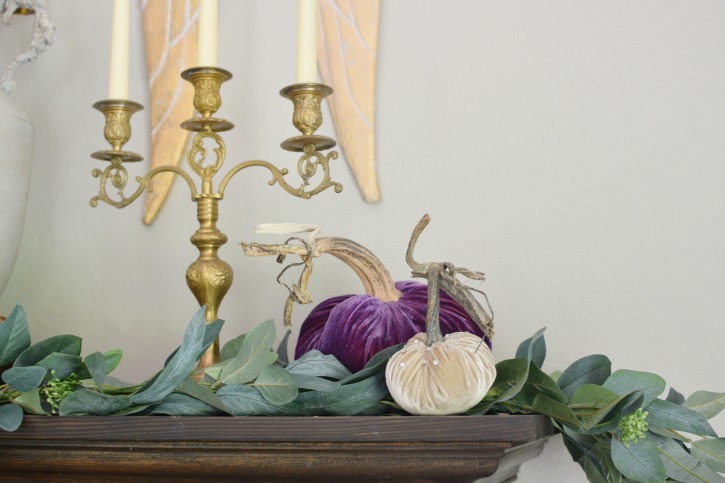 2 velvet pumpkins on mantel with gold candelabra