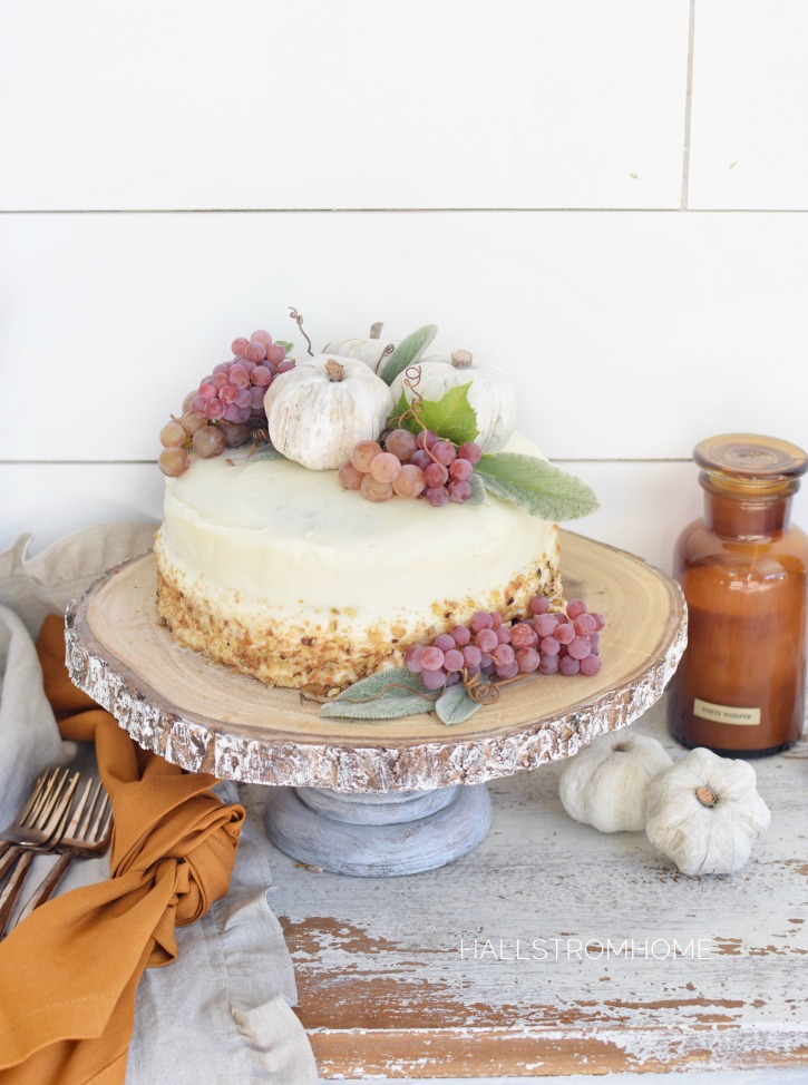 How to Make the Best Pumpkin Spice Cake with Cream Cheese Frosting with white cake and clumps of grapes and 3 white pumpkins on top