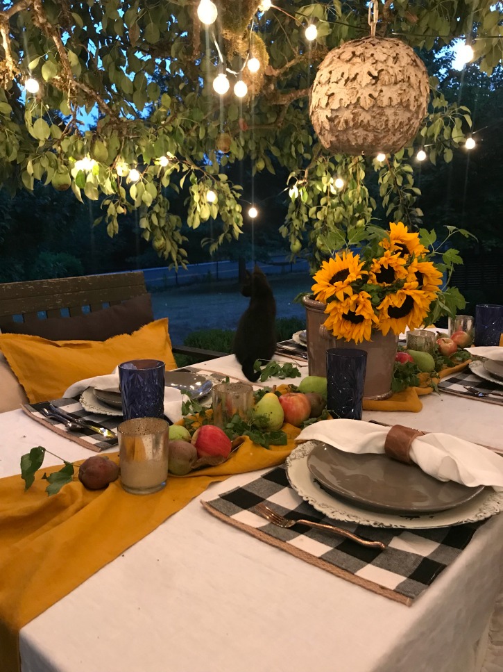 table with buffalo check placemats 4 and yellow table runner with apples and leabes and silver candles