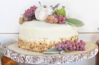 How to Make the Best Pumpkin Spice Cake with Cream Cheese Frosting with white cake and clumps of grapes and 3 white pumpkins on top