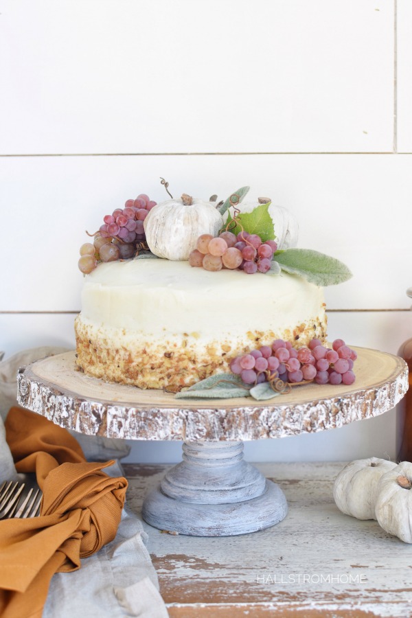 How to Make the Best Pumpkin Spice Cake with Cream Cheese Frosting with white cake and clumps of grapes and 3 white pumpkins on top