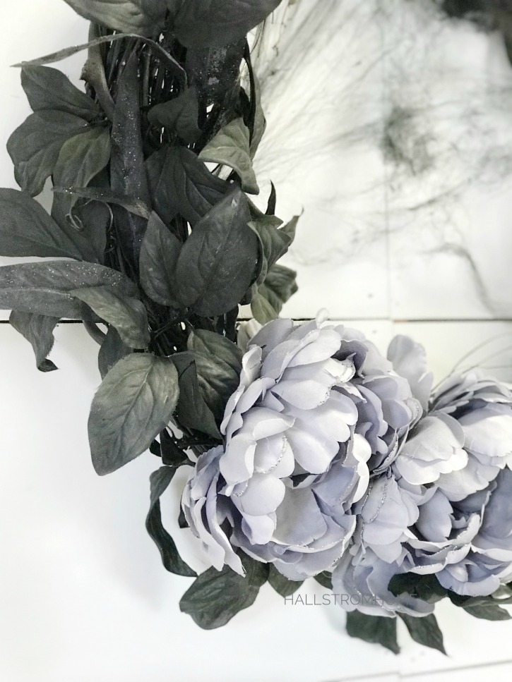 black leaves and purple flowers on black grapevine wreath