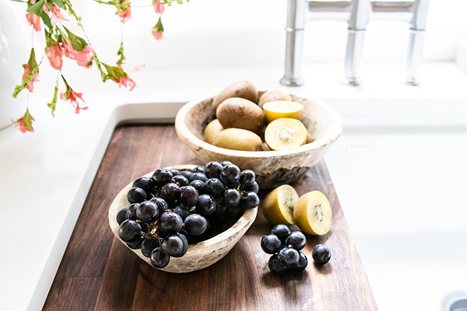 9 Kitchen Sink Style Tips |Farmhouse Kitchen sink|farmhouse style|farmhouse kitchen|white farmhouse|style kitchen|how to style kitchen|white kitchen|modern white kitchen|gold kitchen|shabby chic kitchen|kitchen update|kitchen remodel|kitchen sink|style a kitchen sink|charcuterie board|wood board|white pear|wood pedestal|wood tray|mango wood| Hallstrom Home